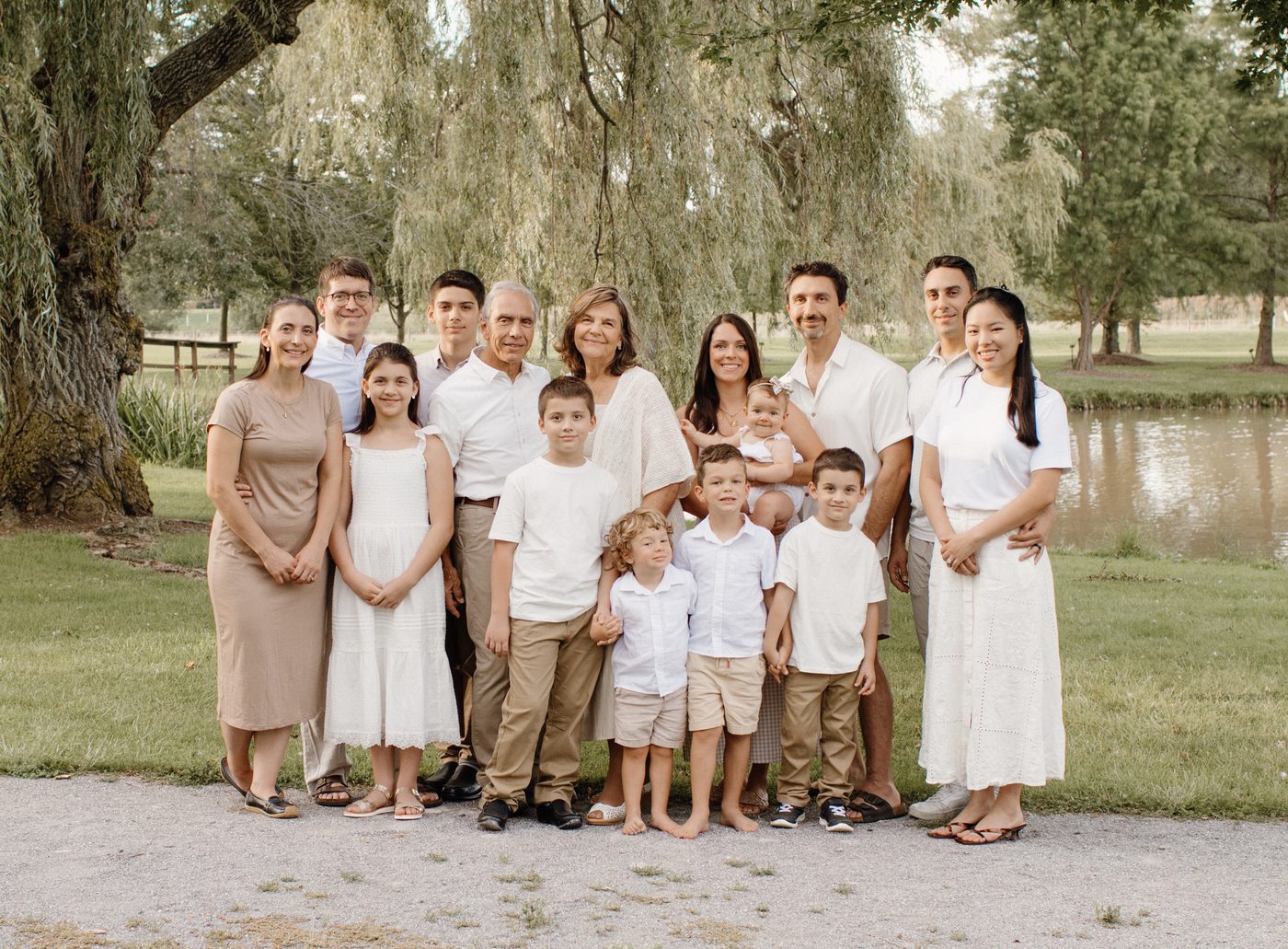 Large extended family gathered under a willow tree at golden hour — Home Team Photography