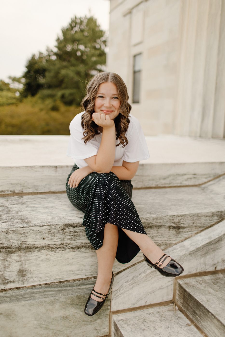 Senior portrait of a girl seated on stone steps — Home Team Photography